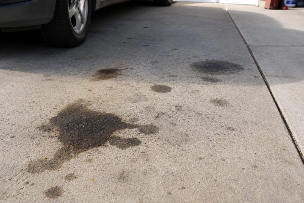 Dark oil stains from a vehicle on a residential concrete driveway in Raleigh and Cary, NC